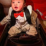 Maverick joined the competition — help win amazing prizes! baby, child, tuxedo, red_bow_tie, gold_chain, toy_car, audi, indoor, seat, steering_wheel, clothing, footwear, portrait, cute, expression, person, fashion, luxury, car_seat, head