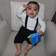 Ilyan a rejoint le concours — aidez-le/la à gagner de superbes lots ! baby, infant, child, armchair, pillow, suspenders, white_shirt, fabric_book, toy, barefeet, sitting, portrait, indoors, cute, curious_expression, big_eyes, cushion, home, photography, smile
