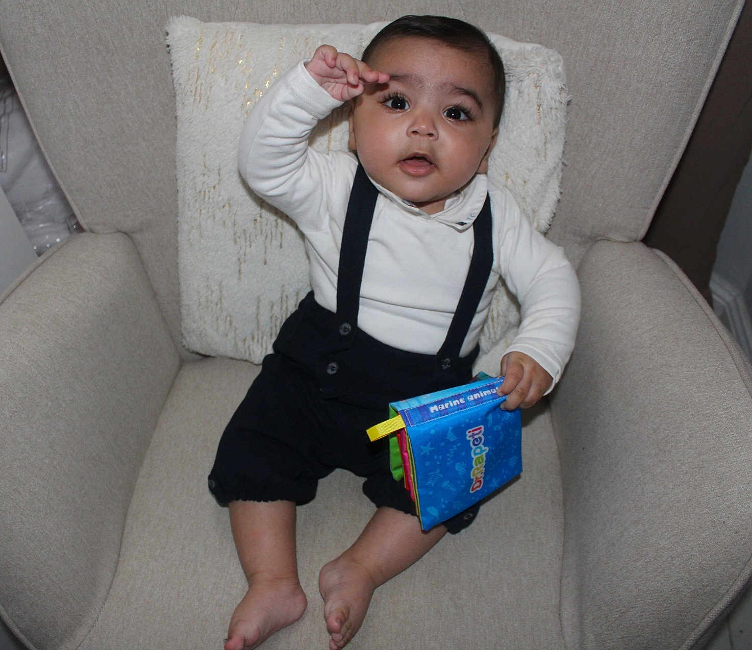 Ilyan a rejoint le concours — aidez-le/la à gagner de superbes lots ! baby, infant, child, armchair, pillow, suspenders, white_shirt, fabric_book, toy, barefeet, sitting, portrait, indoors, cute, curious_expression, big_eyes, cushion, home, photography, smile