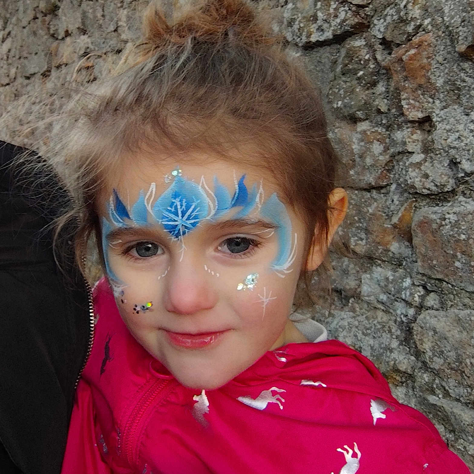 Wendy participe au concours pour gagner de l'argent avec cette photo : blue, child, closeup, cute, face_painting, fashion, happy, outdoor, person, pink_jacket, portrait, silver, smile, snowflake, sparkle, stone_wall, unicorn, white, winter_theme, young