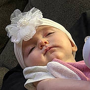 Alora is registered to the contest to win money with this photo: baby, infant, sleeping, headband, flower, pacifier, couch, blanket, close_up, portrait, adorable, cheeks, newborn, hat, soft_texture, skin, clothing, arm, relaxing, indoors