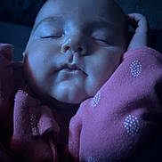 Alora is registered to the contest to win money with this photo: baby, infant, sleeping, close_up, face, chubby_cheeks, pink_clothing, polka_dot, arm, hand, peaceful, portrait, low_light, soft_lighting, indoors, cushion, cozy, relaxed, mouth, nose