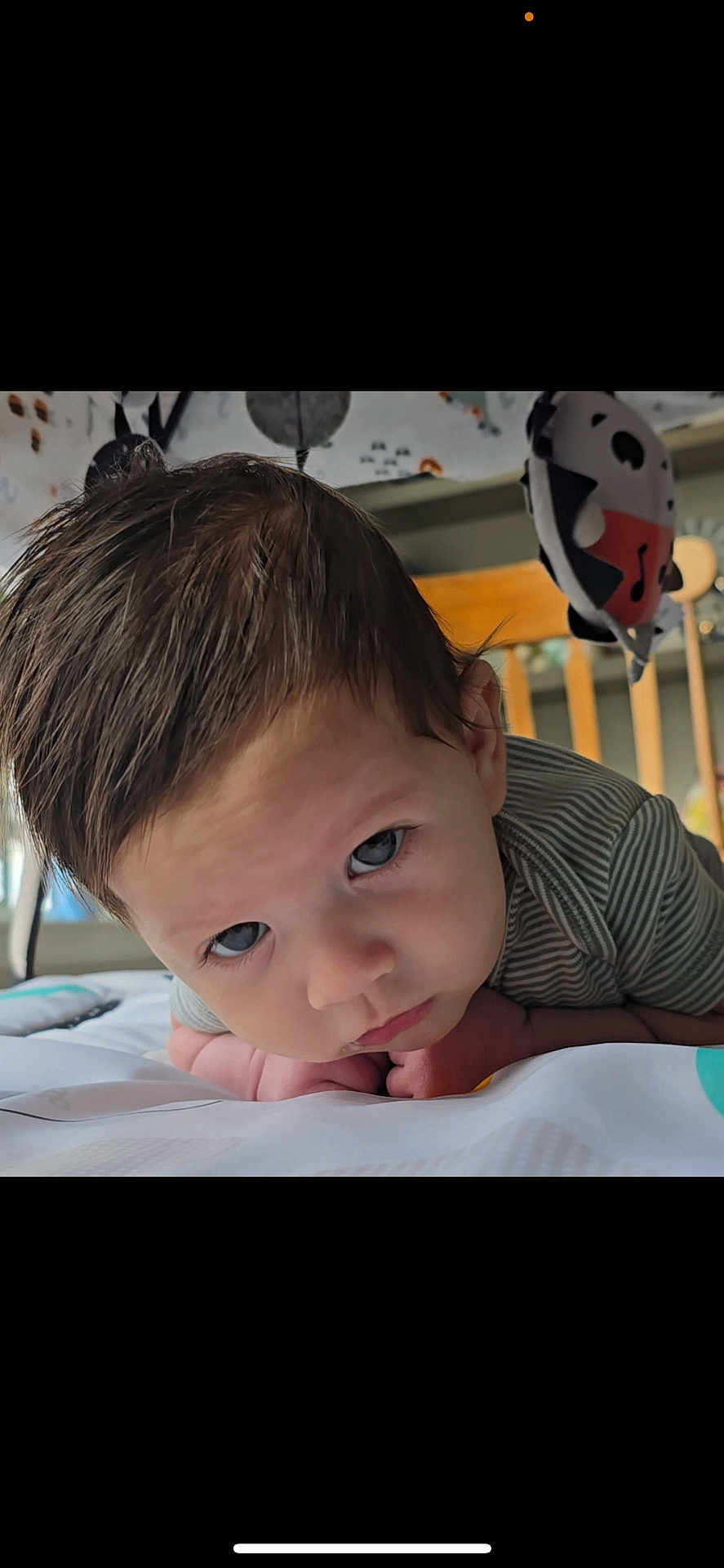Hunter joined the competition — help win amazing prizes! baby, infant, child, face, blue_eyes, hair, crib, toy, nursery, tummy_time, close_up, expression, curious, indoor, person, cute, striped_clothing, skin, head, lying_down