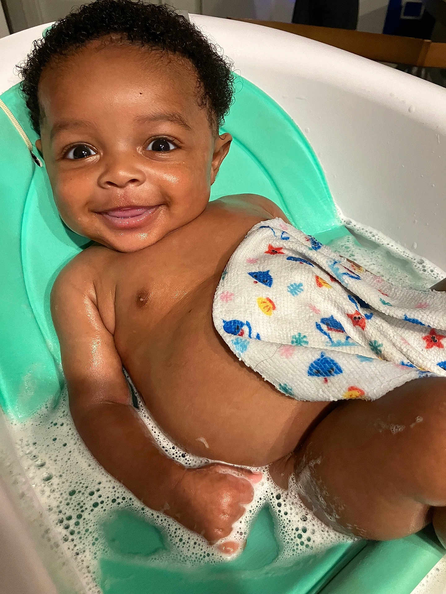 Ksyn is registered to the contest to win money with this photo: baby, bath, bathtub, water, bubbles, smile, towel, child, skin, cute, happy, infant, seat, foam, sitting, wet, person, indoors, head, small