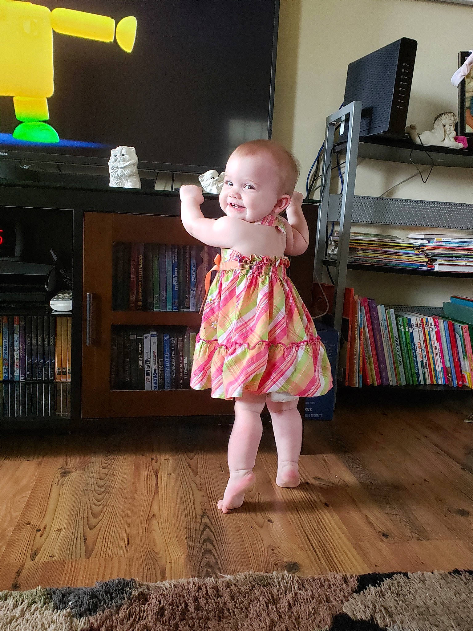 Brooklyn is registered to the contest to win money with this photo: child, dress, floor, flooring, furniture, leg, person, play, room, sitting, standing, toddler, wood