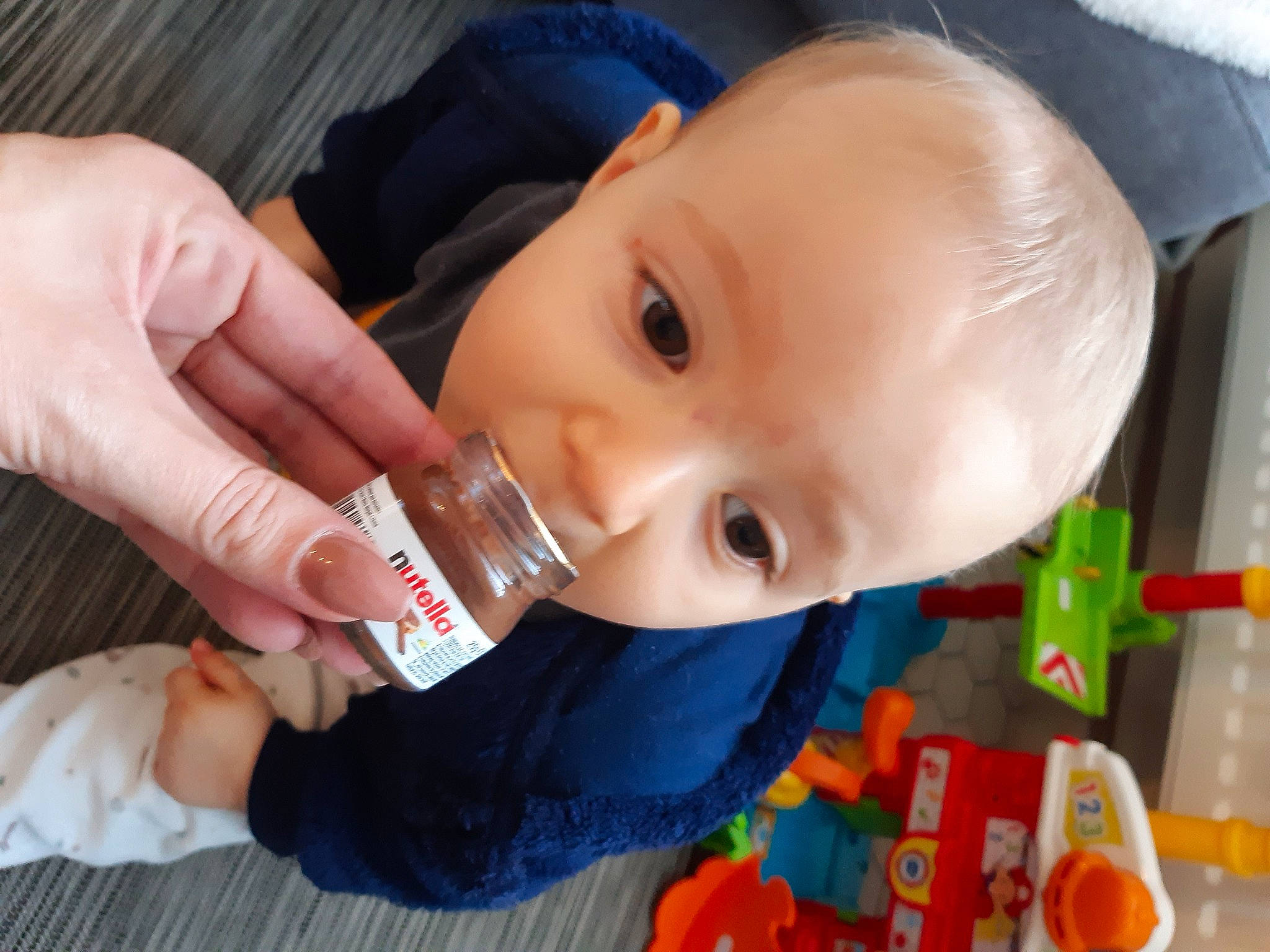Maé participe au concours pour gagner de l'argent avec cette photo : baby, baby_products, baby_toddler_clothing, cheek, child, drinkware, eye, eyelash, finger, fun, gesture, iris, lip, mouth, nose, person, skin, smile, thumb, toddler