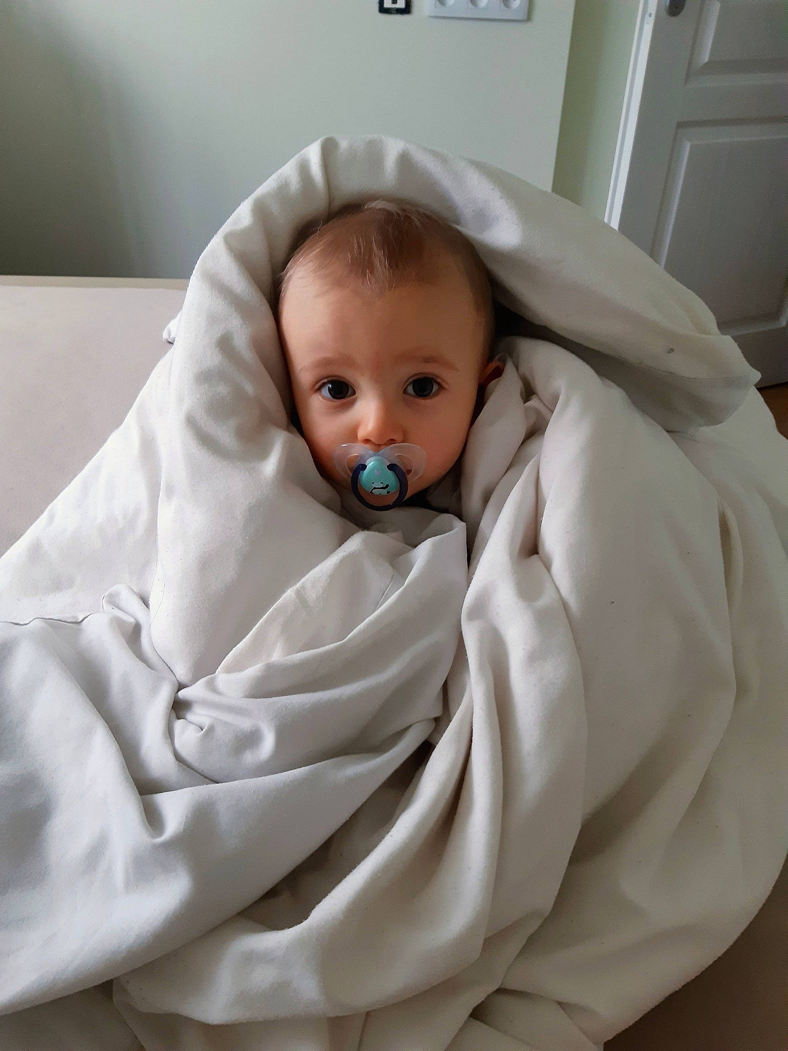 Maé participe au concours pour gagner de l'argent avec cette photo : baby, baby_products, baby_safety, baby_sleeping, baby_toddler_clothing, bed_sheet, bedding, blanket, cheek, child, comfort, door, eyebrow, fur, linens, person, room, sitting, sleeve, toddler