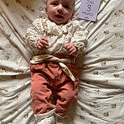 Zoé participe au concours pour gagner de l'argent avec cette photo : baby, blanket, card, child, clothing, cute, face, hand, indoors, infant, lying_down, pants, pattern, portrait, ruffles, sheep, smile, socks, soft_lighting, text