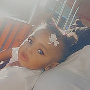 Jatajah is registered to the contest to win money with this photo: adult, bench, casual, child, clothing, cute, expression, face, girl, hair_accessory, indoor, leaning, metal_bars, portrait, soft_light, sunlight, toddler, white_bow, white_shirt, young_child