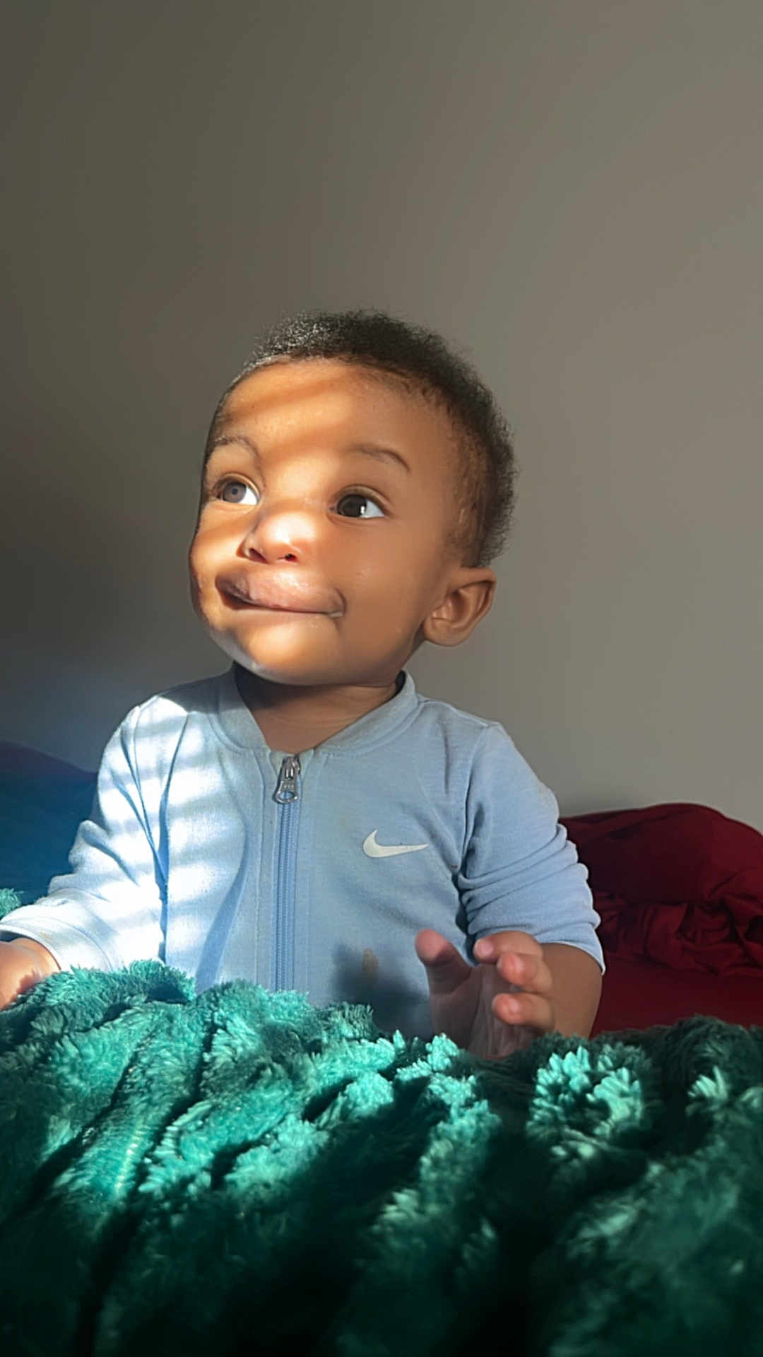 Brynden joined the competition — help win amazing prizes! toddler, child, baby, face, smile, curly_hair, light, shadow, blanket, bed, clothing, nike, indoor, portrait, expression, hand, fingers, cozy, cute, young