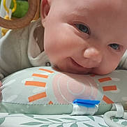 Ambre a rejoint le concours — aidez-le/la à gagner de superbes lots ! baby, infant, smile, face, hand, pillow, toy, bed, blanket, play, cute, child, indoor, closeup, soft, pattern, colorful, cozy, happy, young