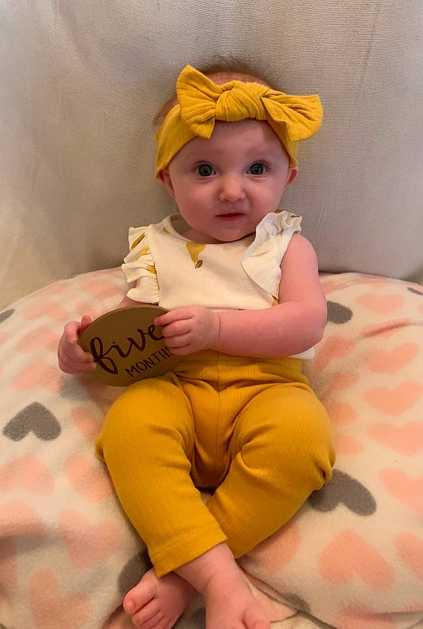 Kinslee is registered to the contest to win money with this photo: abdomen, baby, baby_toddler_clothing, cheek, child, comfort, fashion_accessory, foot, fun, happy, head, headwear, human_body, human_leg, knee, linens, person, pink, skin, sleeve