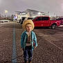 child, boy, cowboy_hat, boots, coca_cola, parking_lot, night, stadium, streetlight, shirt, jeans, truck, vehicle, outdoor, person, standing, casual_clothing, young, curious, urban