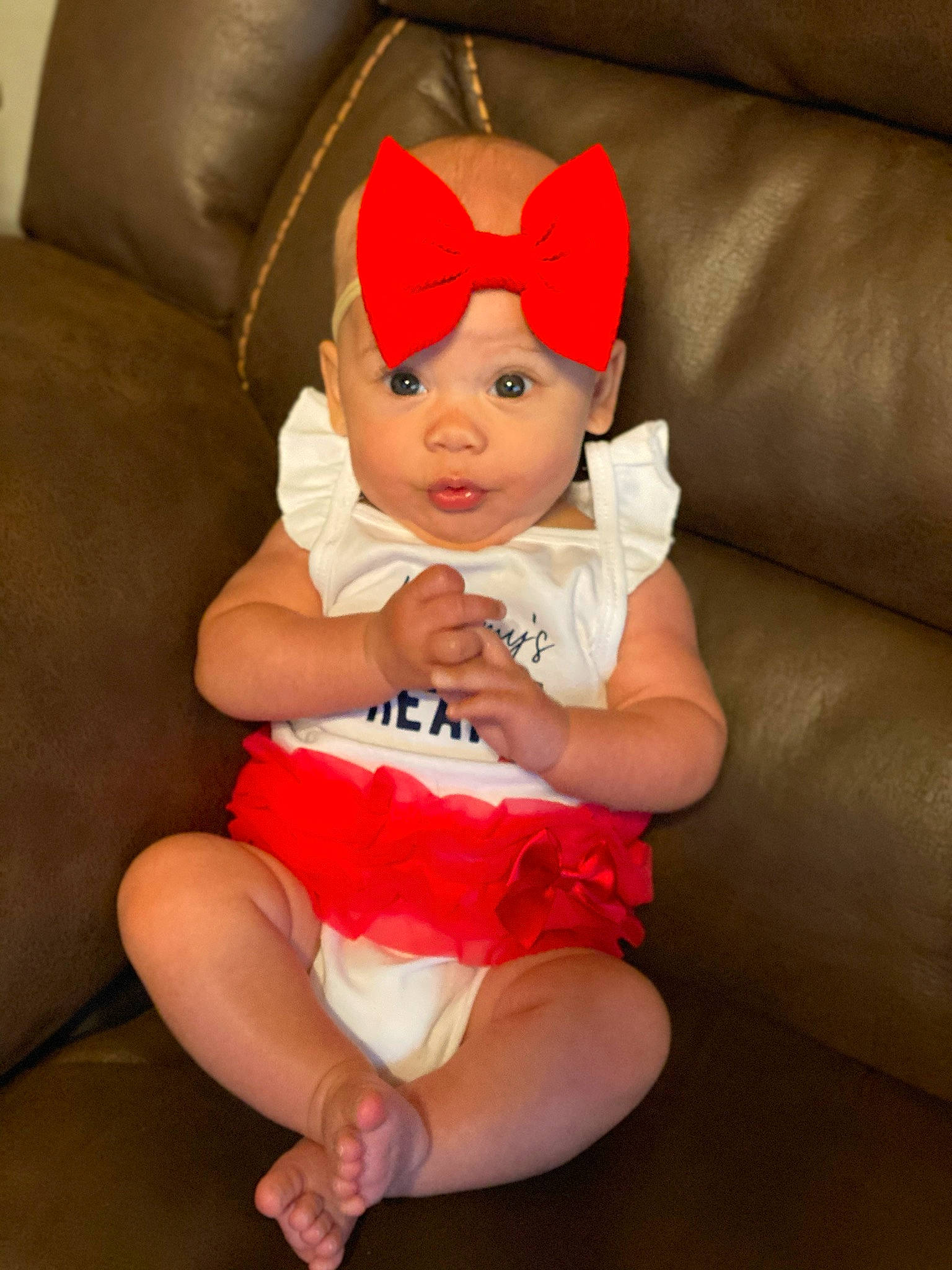 Mykah is registered to the contest to win money with this photo: arm, baby, child, costume, costume_accessory, ear, finger, headgear, headwear, leg, lip, person, red, sitting, thigh, toddler