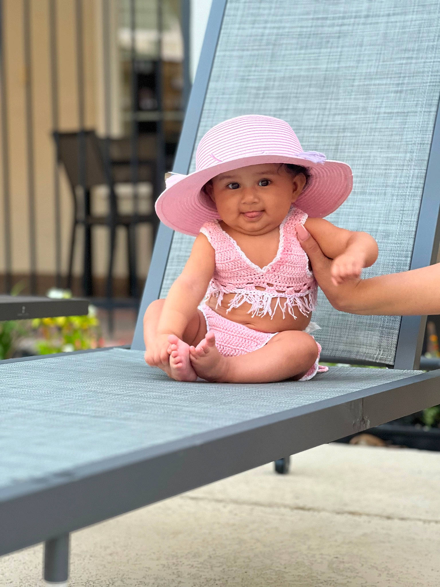 Camila is registered to the contest to win money with this photo: baby, baby_toddler_clothing, blond, child, fun, happy, hat, headwear, human_leg, leisure, magenta, outdoor_furniture, pattern, person, pink, recreation, sitting, smile, sun_hat, table