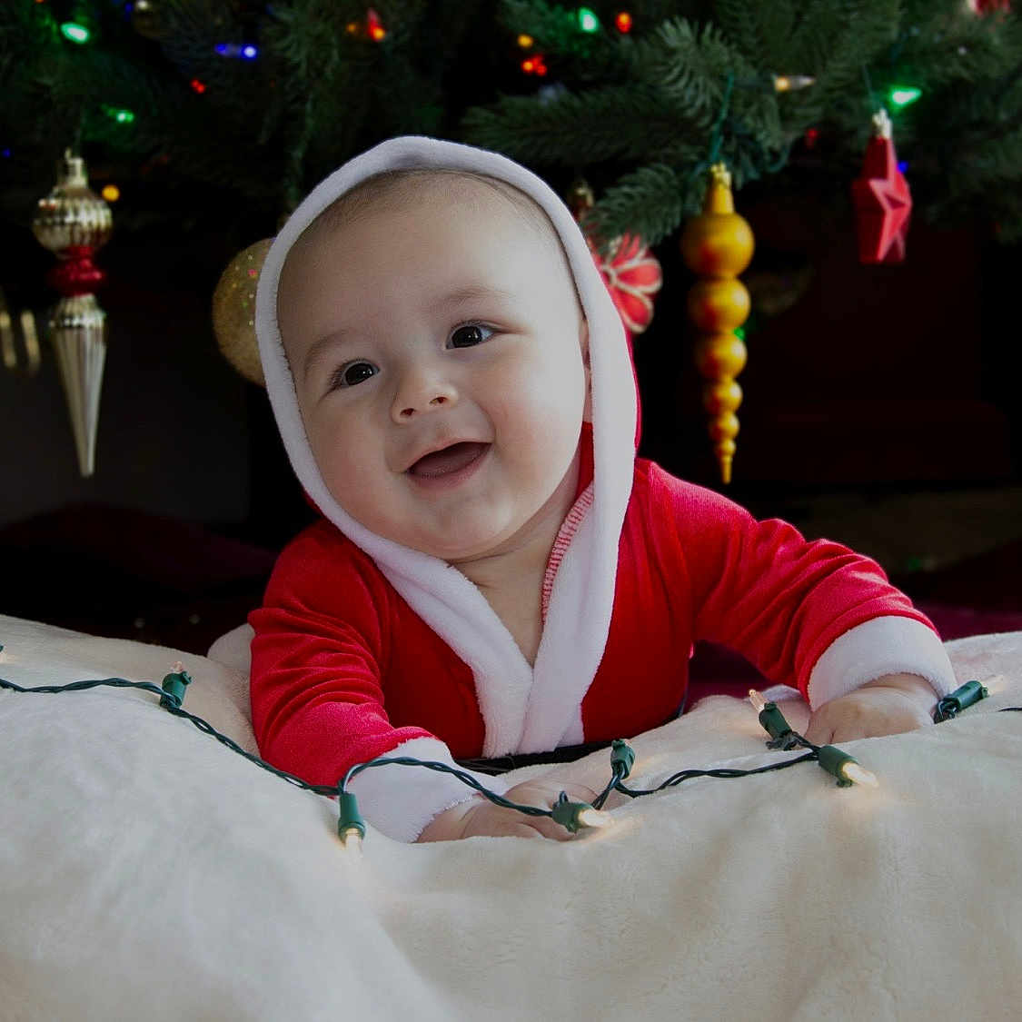Damien joined the competition — help win amazing prizes! baby, celebration, child, christmas_lights, christmas_tree, cute, decorations, face, festive, happy, holiday, holiday_spirit, indoors, infant, ornaments, portrait, red_clothing, seasonal, smiling, white_fabric