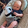 Atlas is registered to the contest to win money with this photo: baby, infant, plush_toy, panda, baby_seat, baby_trend, clothing, foot, hand, face, person, indoor, soft_texture, cushion, patterned_fabric, comfort, child, seated, relaxed, cute