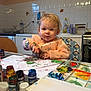 Livya participe au concours pour gagner de l'argent avec cette photo : toddler, child, painting, finger_painting, paint, colorful, hands, table, smock, kitchen, highchair, palette, jars, paper, art, messy, curly_hair, indoor, person, face