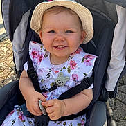 Livya participe au concours pour gagner de l'argent avec cette photo : toddler, child, smiling, stroller, hat, floral_dress, sun_hat, happy, outdoor, baby, cute, clothing, person, seatbelt, hands, toy, daylight, face, young_child, baby_accessory