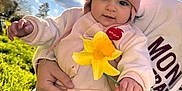 Romy participe au concours pour gagner de l'argent avec cette photo : baby, child, clouds, cute, daffodil, flower, grass, hand, hat, holding, nature, outdoor, person, pink, portrait, sky, smile, spring, sunlight, warm_clothing