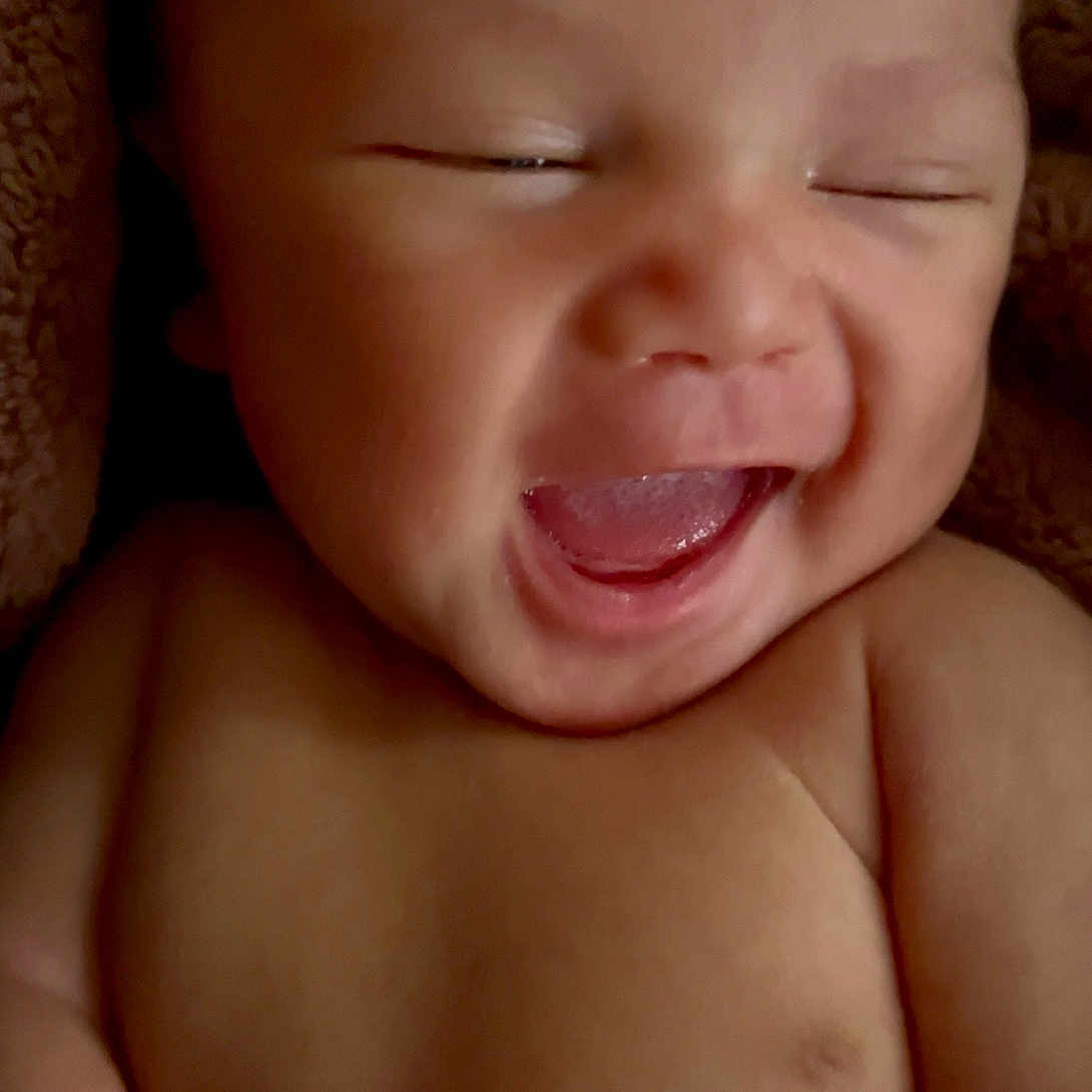 Julian is registered to the contest to win money with this photo: baby, smiling, laughing, infant, skin, face, closed_eyes, mouth_open, happy, cute, newborn, child, bare_chest, blanket, soft_texture, adorable, portrait, young, human, closeup