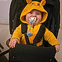 Myllan participe au concours pour gagner de l'argent avec cette photo : baby, pacifier, hoodie, yellow_clothing, stroller, child, smile, happy, indoor, seatbelt, cute, infant, face, hands, clothing, toy, furniture, childhood, portrait, cozy