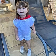 Emy participe au concours pour gagner de l'argent avec cette photo : bench, blue_eyes, casual, child, curly_hair, daylight, lounge_chair, outdoor, patio, playful, potted_plant, red_scarf, shorts, smiling, sneakers, standing, statue, stone_floor, toddler, white_clothing