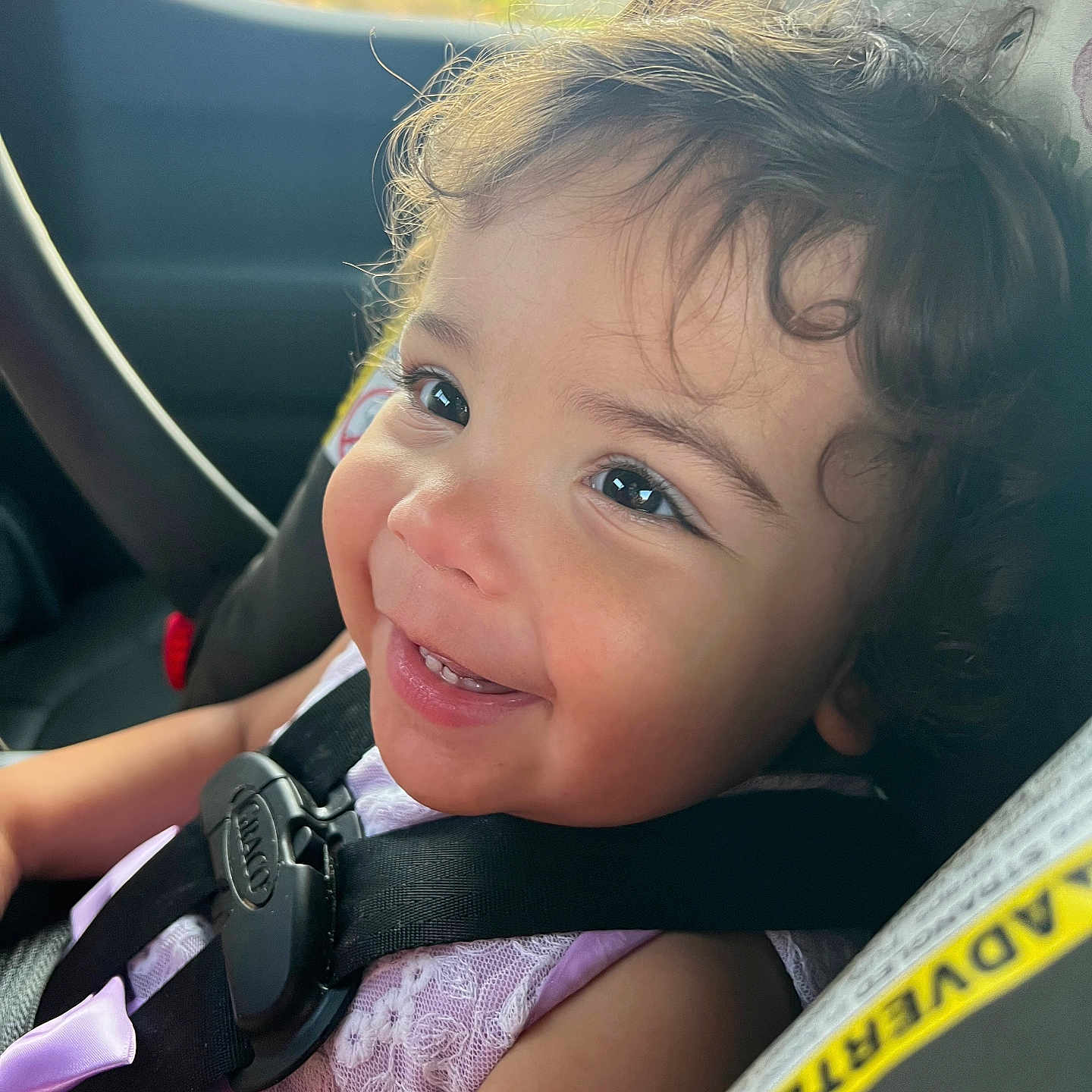 Carli Reneé is registered to the contest to win money with this photo: baby, car_interior, car_seat, child, close_up, curly_hair, cute, face, happy, indoors, lace_dress, person, portrait, safety, seatbelt, secure, smiling, sunlight, toddler, young_child