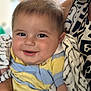 baby, smiling, child, blanket, striped_shirt, person, face, cheeks, arm, holding, patterned_clothing, adult, close_up, indoor, soft_light, happy, cute, portrait, infant, comfort