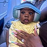 Leilani joined the competition — help win amazing prizes! adult, airplane_cabin, airplane_window, baby, baby_headphones, child, closeup, curious_expression, hand, headphones, infant, interior, manicured_nails, person, ring, seated, striped_headband, travel, window, yellow_outfit