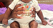 Leilani joined the competition — help win amazing prizes! baby, blanket, carpet, child, colorful_nails, curly_hair, cute, expression, floor, furniture, hands, home, indoor, infant, nails, onesie, person, seated, socks, soft_lighting
