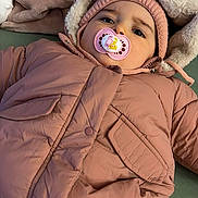 Célia a rejoint le concours — aidez-le/la à gagner de superbes lots ! baby, baby_clothes, blanket, bottle, child, cozy, cute, face, fuzzy_hood, indoor, infant, knit_hat, lying_down, pacifier, person, pink_jacket, resting, soft_texture, warm_clothing, winter_wear