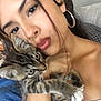Tigger is registered to the contest to win money with this photo: woman, kitten, cat, face, closeup, portrait, earrings, holding, pet, feline, tabby, indoor, young_adult, affection, casual, skin, hair, eyes, hand, shoulder