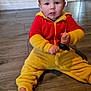 Bradley is registered to the contest to win money with this photo: toddler, child, floor, wooden_floor, red_clothing, yellow_clothing, onesie, baby, indoor, home, toy, baby_gate, curious, sitting, person, young_child, casual, candid, expression, hand