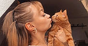 Oslo a rejoint le concours — aidez-le/la à gagner de superbes lots ! woman, cat, orange_cat, kiss, face, earrings, indoor, portrait, pet, affection, hair, holding, cute, feline, expression, animal, young_adult, casual, love, closeup