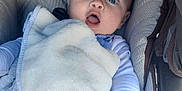 Emylio a rejoint le concours — aidez-le/la à gagner de superbes lots ! baby, infant, blanket, stroller, blue_eyes, cozy, expression, clothing, hand, face, cute, child, comfort, soft, cushion, indoor, young, person, resting, warm