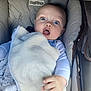 baby, infant, blanket, stroller, blue_eyes, cozy, expression, clothing, hand, face, cute, child, comfort, soft, cushion, indoor, young, person, resting, warm