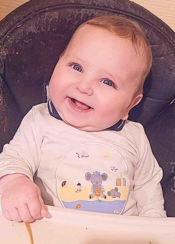 Elesyo participe au concours pour gagner de l'argent avec cette photo : baby, child, smiling, high_chair, cute, happy, infant, clothing, food, snack, portrait, indoor, face, young, person, cheerful, cute_outfit, hand, seat, fun