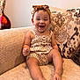 baby, child, smiling, sitting, couch, headband, striped_clothing, happy, indoor, furniture, infant, portrait, cute, toddler, apparel, living_room, fabric, decor, comfort, skin