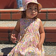 Ashley is registered to the contest to win money with this photo: child, girl, floral_dress, sun_hat, outdoor, steps, tiled_floor, sunlight, shadow, sitting, portrait, young_child, casual_clothing, daylight, cute, summer, fashion, person, background_blur, expression