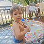 Lenny a rejoint le concours — aidez-le/la à gagner de superbes lots ! baby, child, deck, high_chair, inflatable_pool, necklace, outdoor, person, plastic_chair, play, pool, shade, summer, sunlight, swim_trunks, toddler, toy, trees, water, wooden_floor