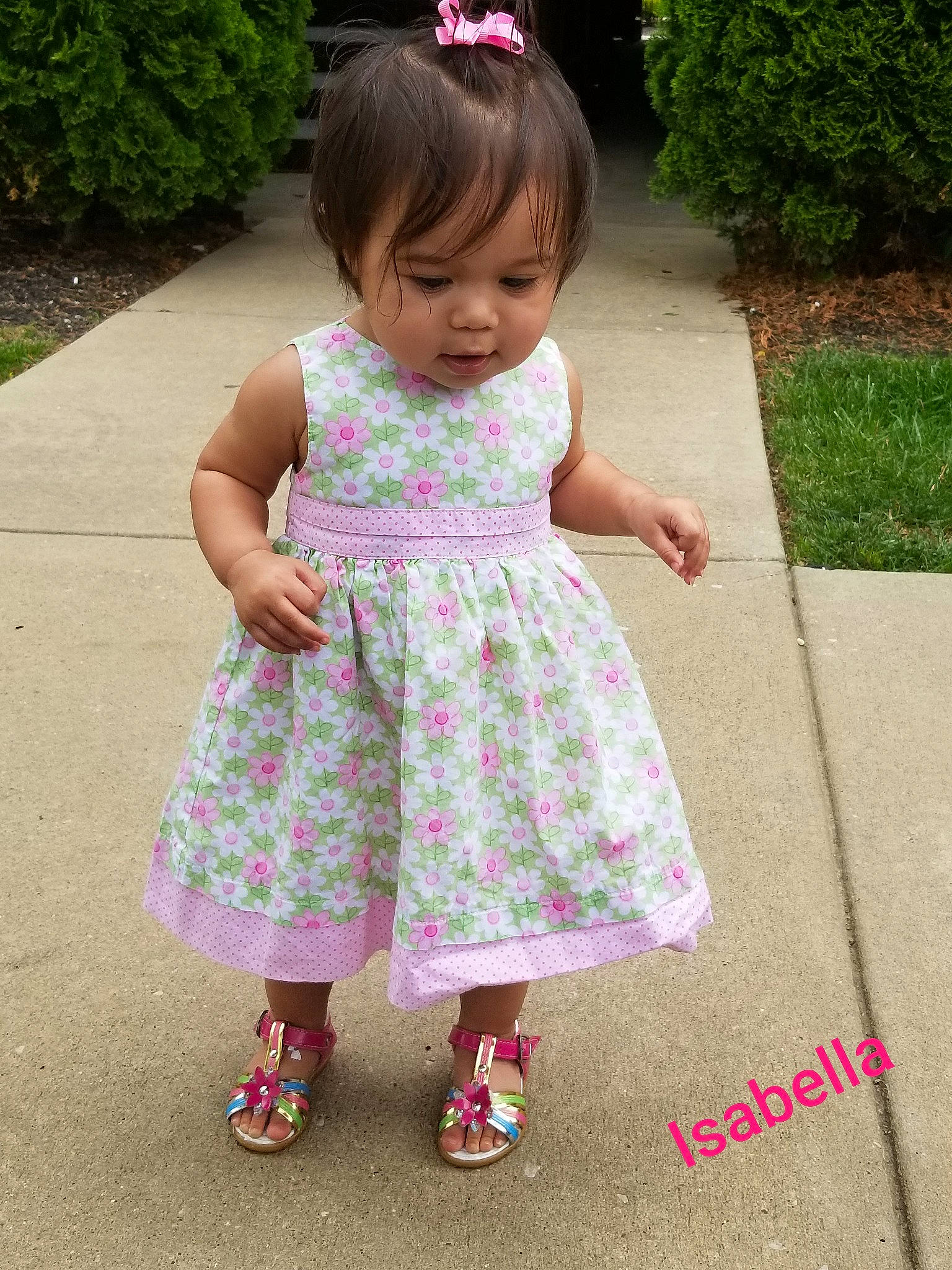 Isabella is registered to the contest to win money with this photo: baby_toddler_clothing, day_dress, dress, facial_expression, grass, green, happy, magenta, mammal, one_piece_garment, pattern, person, pink, plant, purple, shoe, sleeve, summer, toddler, tree