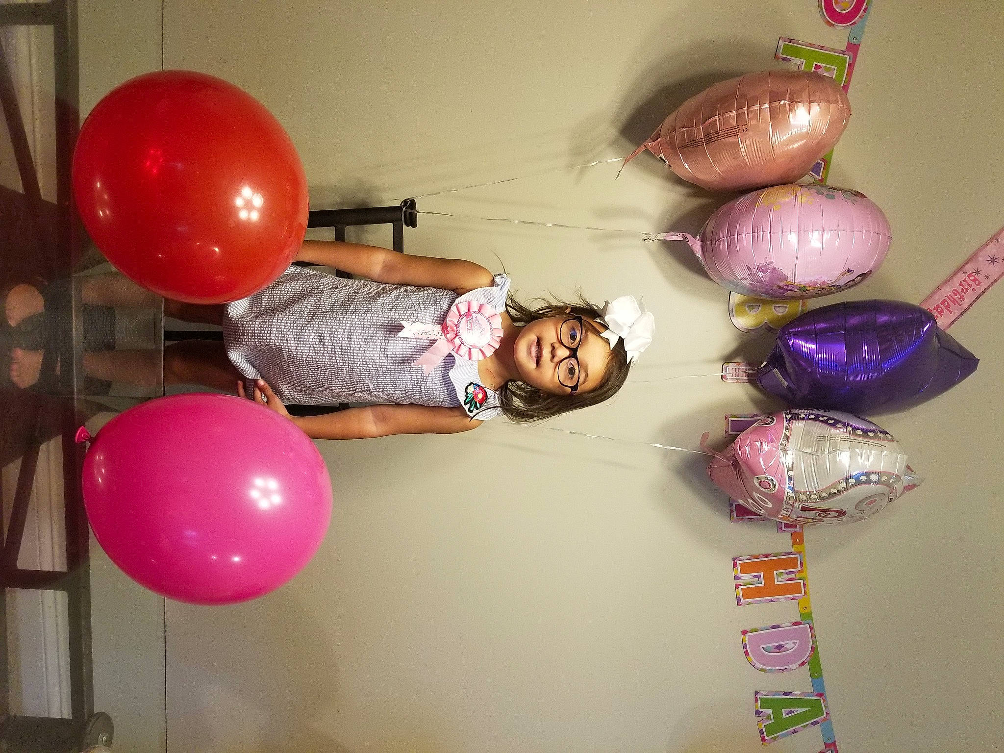 Rosemary is registered to the contest to win money with this photo: balloon, ceiling, event, eyewear, fun, glass, happy, lighting_accessory, magenta, material_property, party_supply, person, pink, purple, room, smile, tableware, thigh