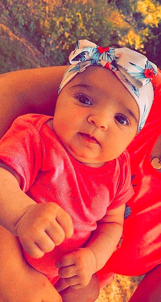 Lilia participe au concours pour gagner de l'argent avec cette photo : baby, baby_toddler_clothing, cap, cheek, child, eyelash, finger, grass, happy, head, headgear, headwear, human_body, lip, mouth, nose, orange, person, pink, skin