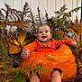 baby, pumpkin, orange_clothing, smiling, autumn_leaves, ferns, fall, cute, holiday, hollow_pumpkin, child, nature, seasonal, indoor, portrait, happy, legs, feet, festive, costume