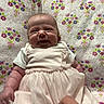 Evee is registered to the contest to win money with this photo: baby, smile, dress, pink, floral, blanket, hand, infant, cute, happy, clothing, tulle, pattern, person, portrait, sitting, fabric, soft, indoors, child