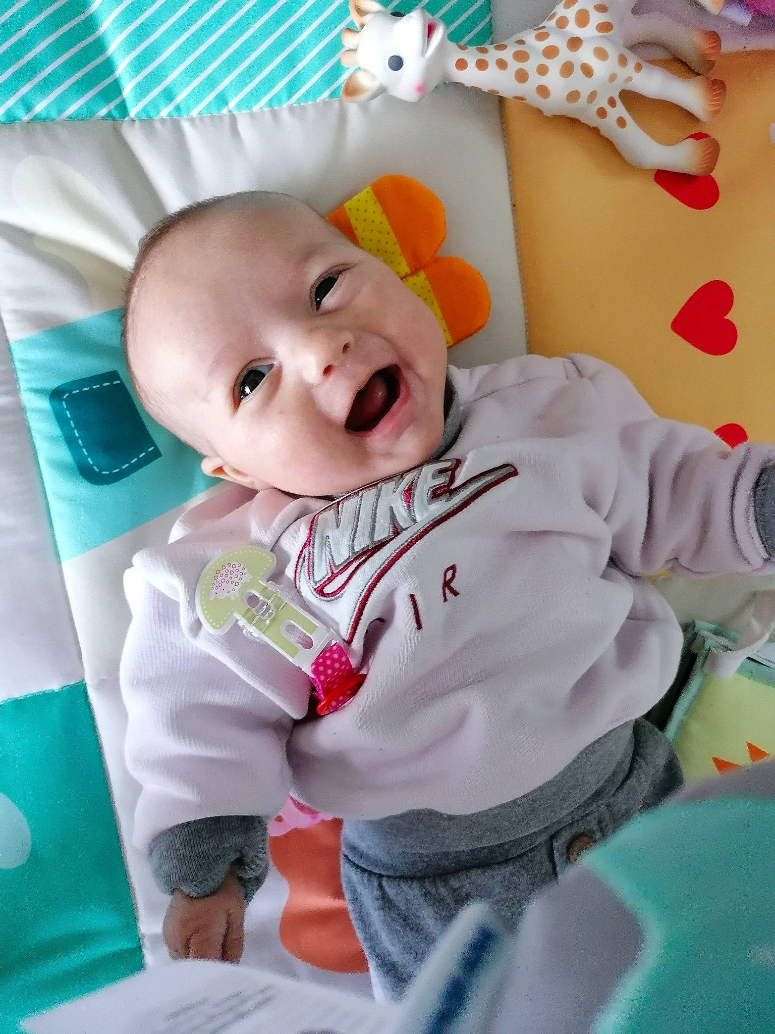 Elly participe au concours pour gagner de l'argent avec cette photo : baby, baby_playing_with_toys, baby_products, baby_toddler_clothing, baby_toys, cheek, child, comfort, fun, happy, infant_bed, linens, orange, person, pink, room, sleeve, smile, textile, toddler