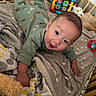 baby, crib, blanket, pajamas, toy, smiling, infant, face, child, bedroom, soft, colorful, cute, playtime, happy, indoors, lying_down, comfort, warm, young_child