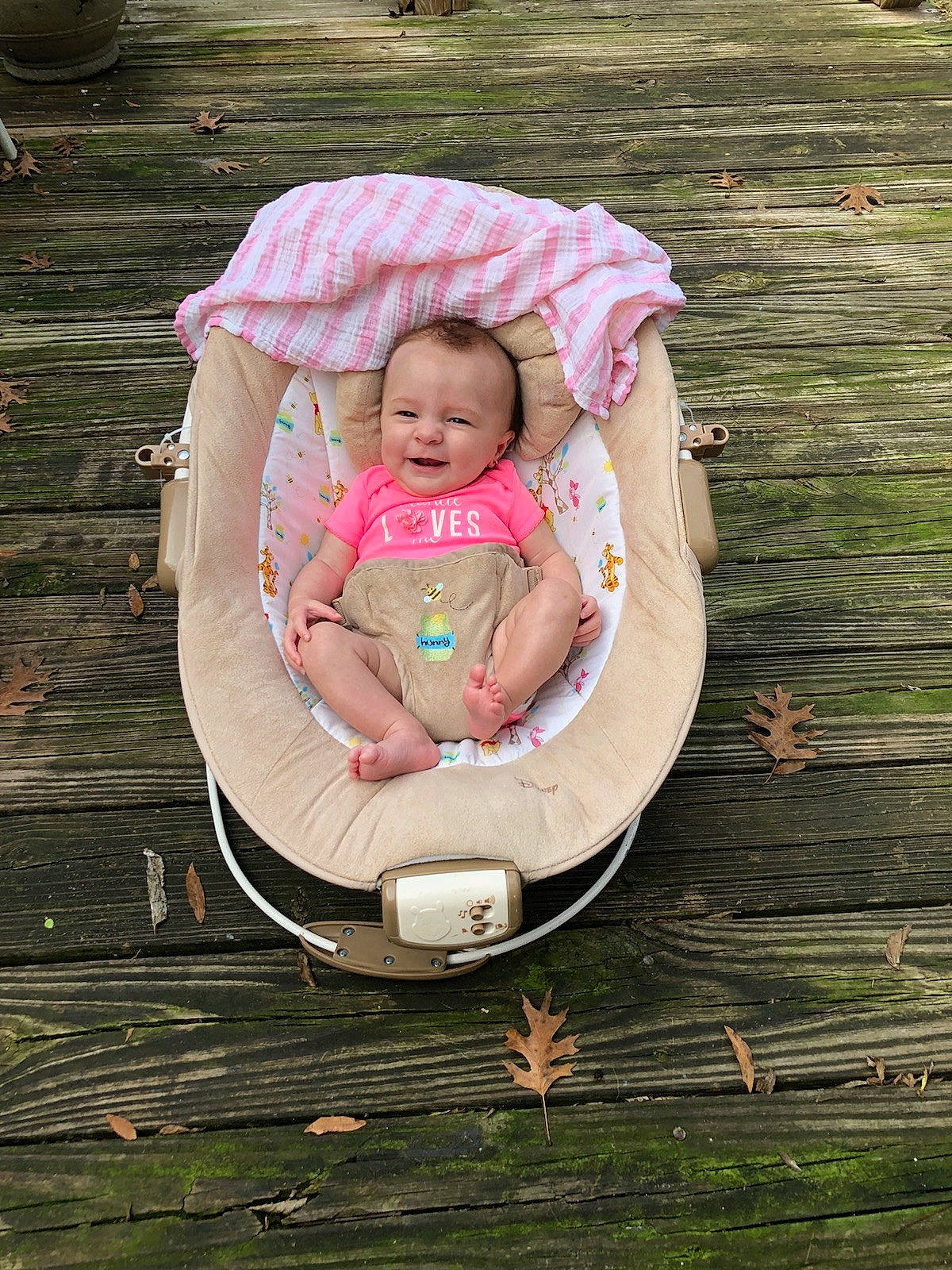 Maria is registered to the contest to win money with this photo: baby_products, child, fun, girl, grass, infant, person, pink, play, product, recreation, sitting, toddler, vacation