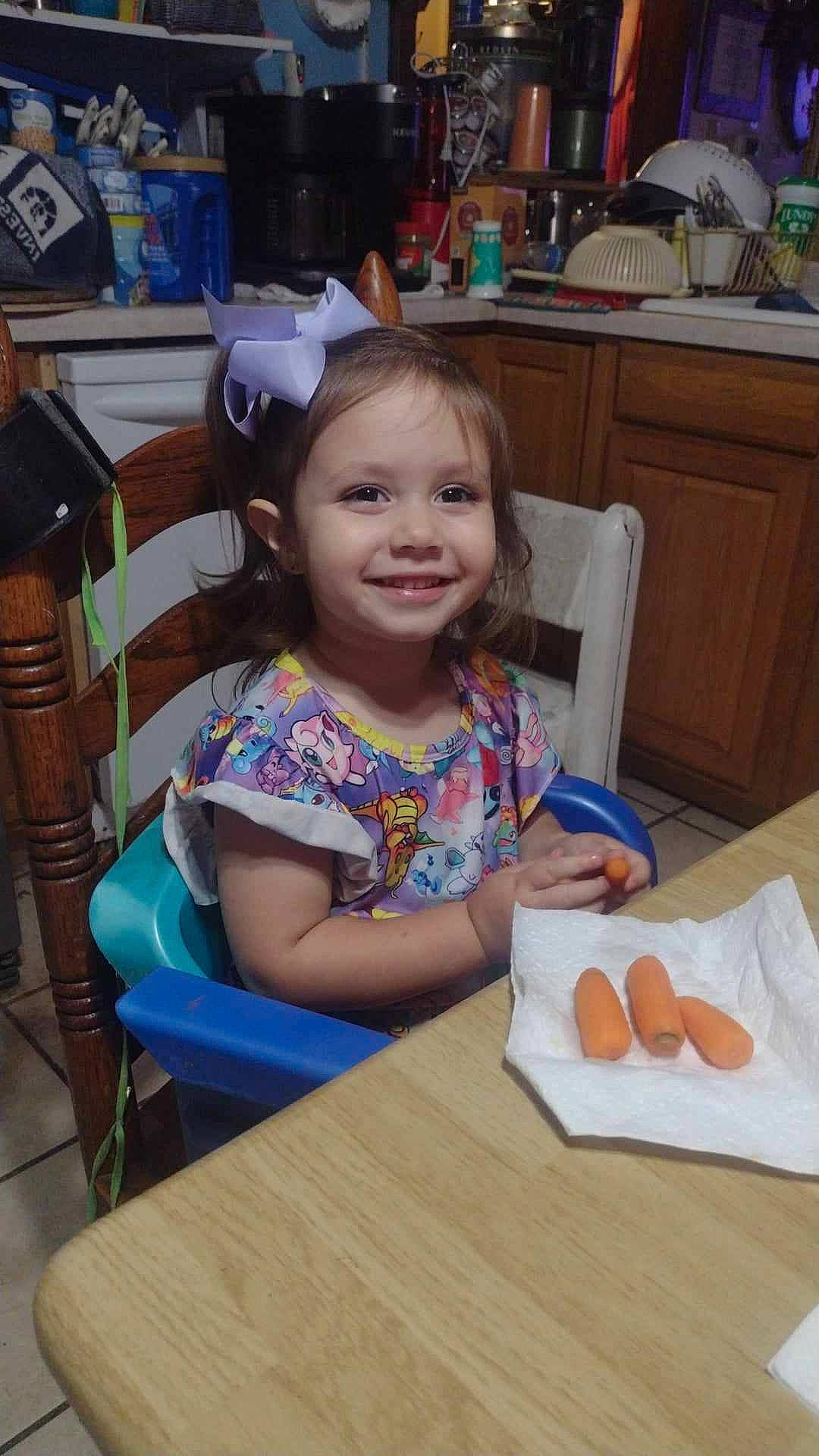 Peyton is registered to the contest to win money with this photo: cabinetry, chair, child, desk, event, flooring, fun, furniture, happy, joy, leisure, person, plate, play, room, sitting, smile, t_shirt, table, tableware